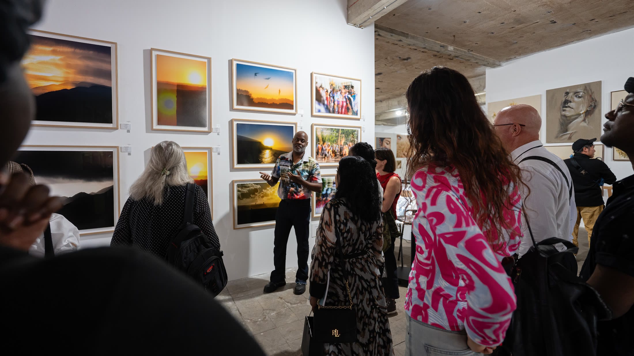 Nigel Ryan speaking with visitors beside his photography at Flux Exhibition in London